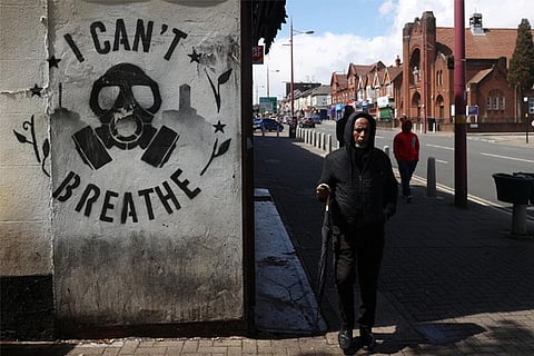 A man walks past graffiti in Handsworth in relation to the death of George Floyd (Reuters)