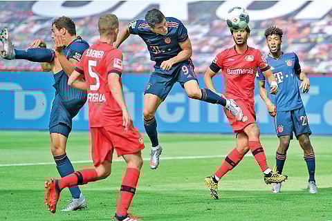 Bayern Munich forward Robert Lewandowski (centre) heads to score his team?s fourth goal