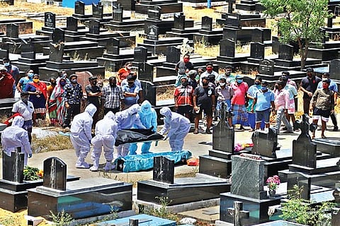 Healthcare workers at a burial ground in city
