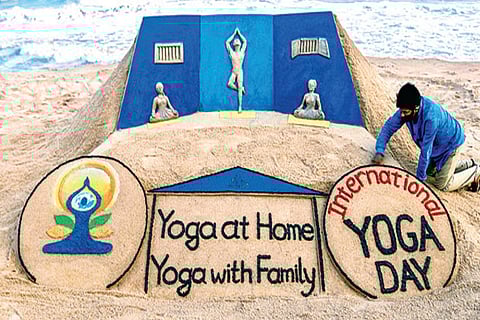 Sand artist creates a sand sculpture on the eve of International Day of Yoga