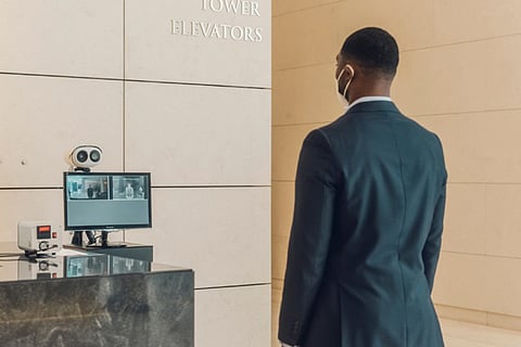 With fever-screening cameras and touch-free ID checks, the office lobby