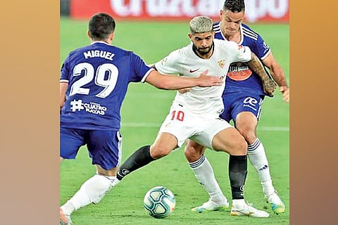 Sevilla?s Ever Banega (centre) vies for the ball against Real Valladolid players