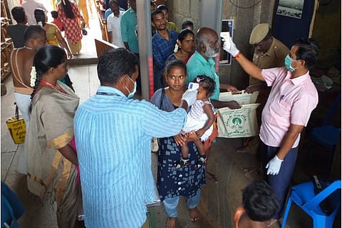 Temple staff screen devotees in Tiruchy on Saturday