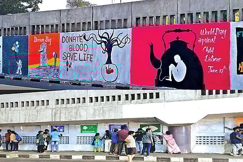 Volunteers painting murals on the walls of the flyover