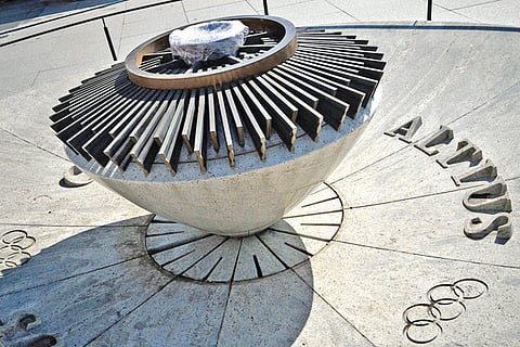 The extinguished cauldron hosting the Olympic flame is protected by a plastic sheet