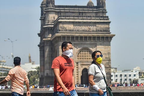 People wear protective masks in view of coronavirus pandemic at the Gateway of India in Mumbai