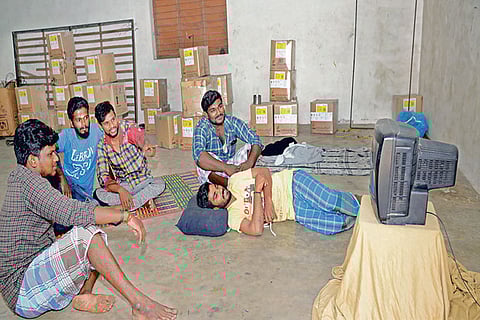 File photo of workers watching television during the lockdown period at a textile unit in Tirupur
