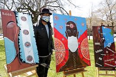 Artist Obi Uwakwe poses with his painting in Chicago. Uwakwe is an photographer