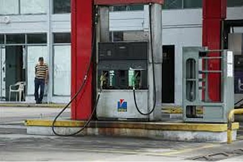 A worker stands at a closed gas station of the state oil company PDVSA in San Cristobal (Reuters)