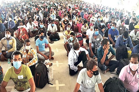Migrant workers waiting to undergo medical screening at a Corporation school in Tirupur