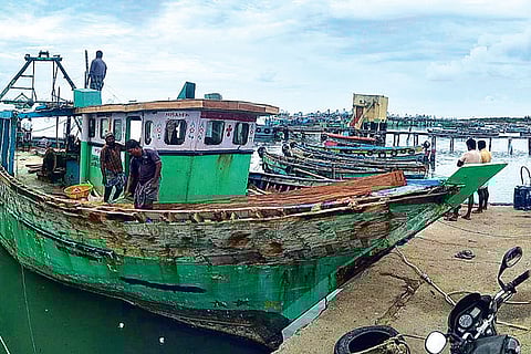 Fishermen carrying out maintenance on a mechanised boat