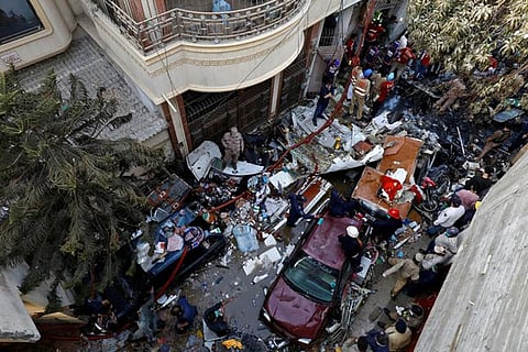 Rescue workers at site of a passenger plane crash in a residential area near an airport in Karachi