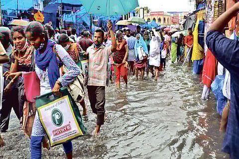People wading through knee deep water on NSB Road in Tiruchy on Friday