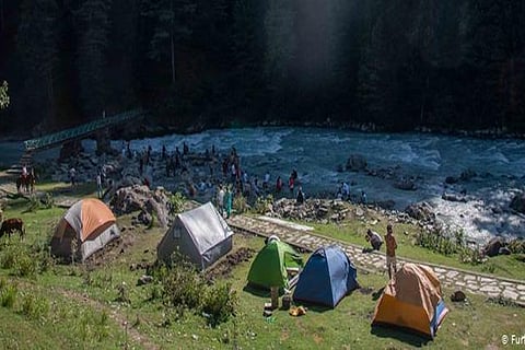 Tourists camp around and enjoy in the waters of river Lidder, that flows through the valley