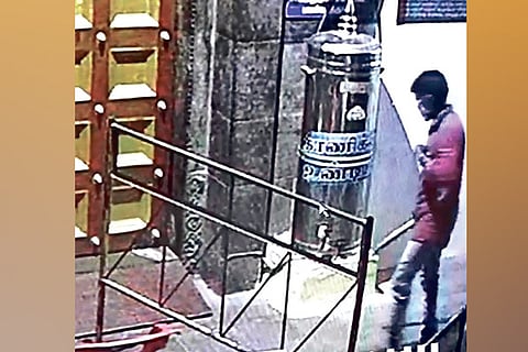 Video grab of the intruder praying beforethe deity before breaking open the hundial