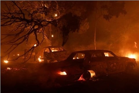 Cars are seen burning as a wildfire blazes out in Northern Athens (Source: Reuters)