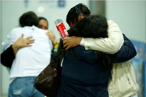People hug each other after reaching Frankfurt airport (Credit: Reuters)