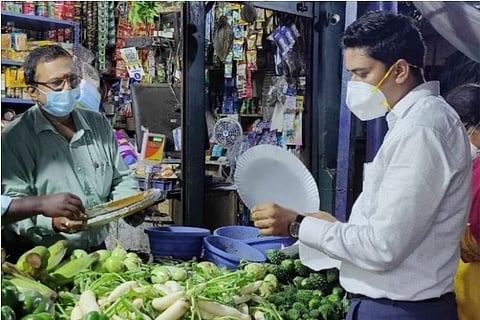 An official is seen inspecting a plastic plate as corporation conducts probe