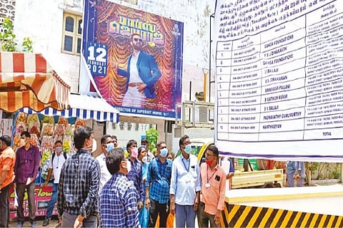 Chennai Corporation officials erecting a banner in front of a shopping mall in Thiru Vi Ka Nagar