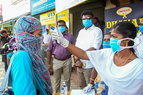 A Heathcare workers checks the temperature of a person (Image credit: PTI)