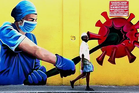 A man walks past a wall mural on Covid-19 awareness in Chennai (Credit: PTI)
