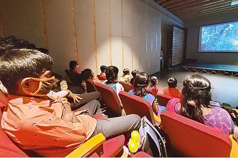 Children enjoying a movie on their visit to a city mall on Saturday
