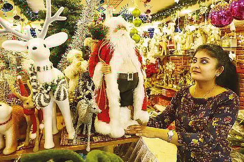 A girls checks Christmas decoration at a shop in Egmore