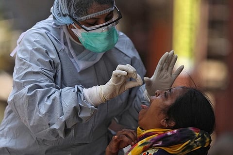 Health worker in Tamil Nadu takes swab sample from a woman