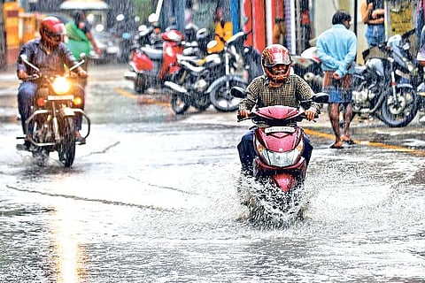 Photo: Justin George, Motorists riding through a water-logged road after heavy downpour in city