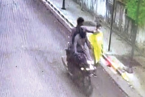 CCTV grab of the snatchers pushing woman
