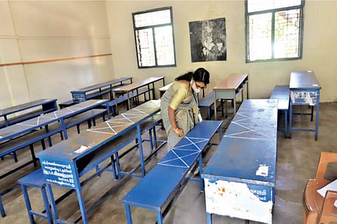 A teacher earmarks space for students in class to ensure social distancing norms on Monday