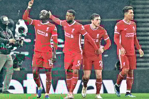 Liverpool players celebrate their third goal against Tottenham Hotspur.