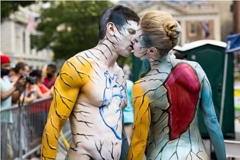 A couple stealing a kiss while participating in Bodypainting (Reuters)