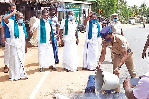 Police pour water on an effigy of Karnataka Chief Minister Yediyurappa that was set on fire