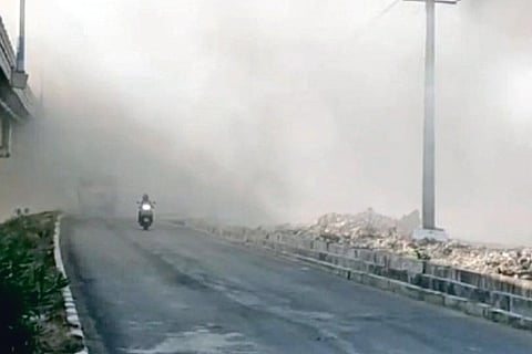 Road adjacent to the dump yard covered in smoke