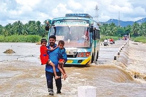 A bus caught in the middle of a causeway submerged in floods across the Palar river near Ambur.