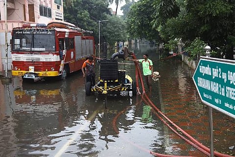Fire department personnel pump out water from a street in T Nagar.