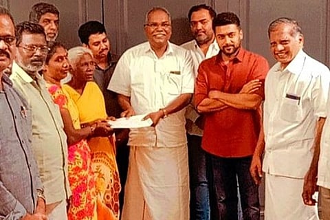 Suriya offering monetary support to Parvati in the presence of CPI(M) leaders. Twitter - @tncpim