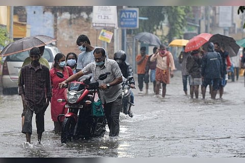 People wade through a flooded street after heavy monsoon rains in Chennai (Image credit: AFP)