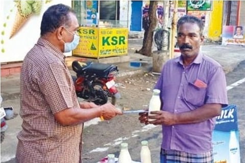 A customer is buying a bottle of milk through KOMILK