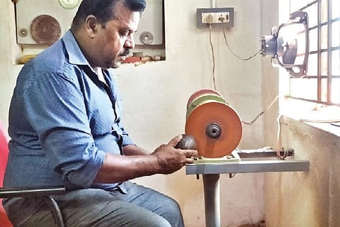 R Kumaraguru working on a machine made by him to polish a coconut shell in Thanjavur