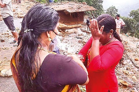 A woman breaks down as her house is damaged in landslide in Kottayam district