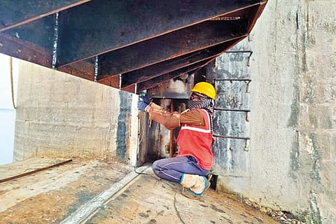 A worker fixing shutters at Sathanur dam in Tiruvannamalai on Monday