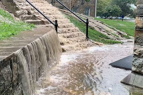 Floodwater inundating the street gushing down the steps.