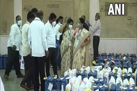 Poll officials inspect the ballot boxes before counting