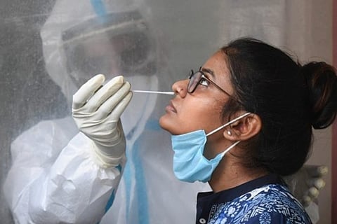 A health worker takes swab samples from a woman (File Photo)