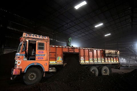A worker shovels coal in a supply truck at yard on the outskirts of India (Image credit: Reuters)