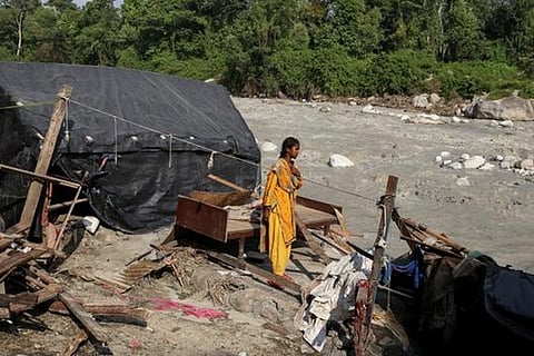 Caption: Reena Bhalekar stands in the location where her house was before the floods swept it away.