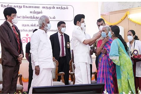 Stalin giving hearing aid to a woman in RGGGH