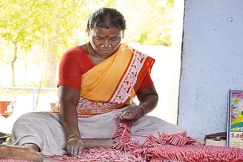 A woman engaged in making crackers at a factory in Sivakasi, Virudhunagar district